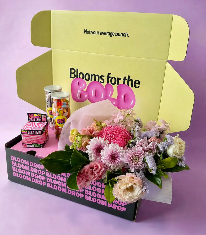 NeeDoh Sensory Gift Bundle featuring a Candy Swirl Nice Cube, $49 Florist Choice flower bunch, rainbow lollies and a bottle of chocolate freckles and milk bottle lollies.